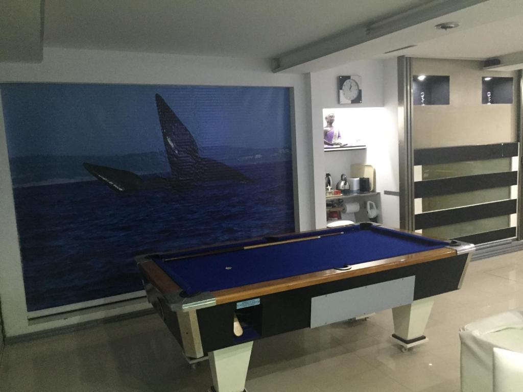 una camera con tavolo da biliardo di fronte a un dipinto di Departamentos Suites a Puerto Madryn