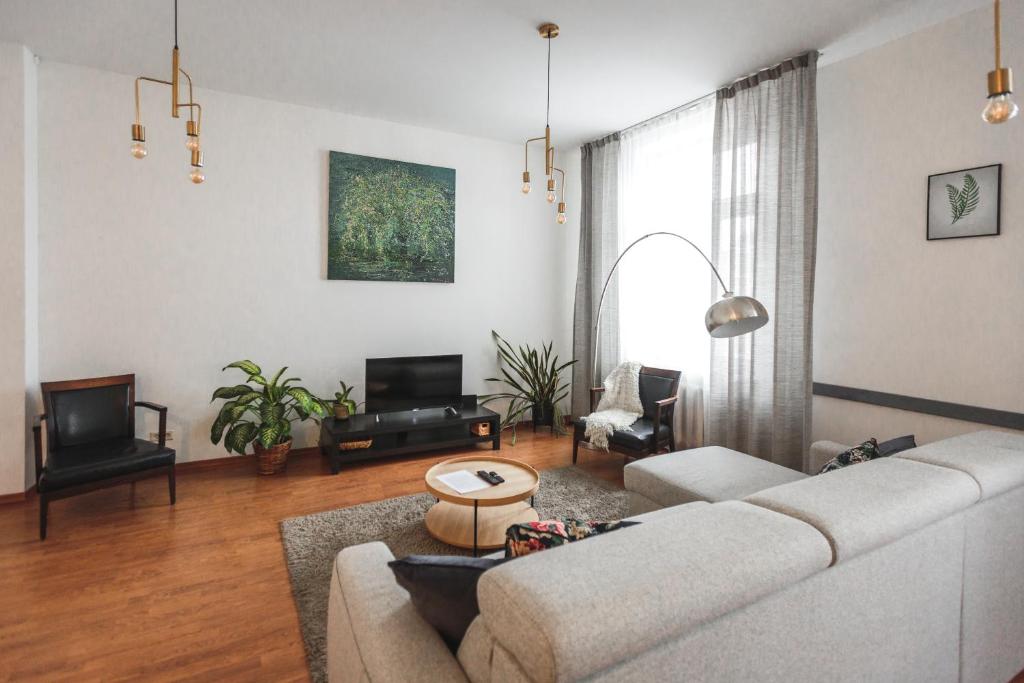 a living room with a couch and a tv at Bearsleys Downtown Apartments in Rīga