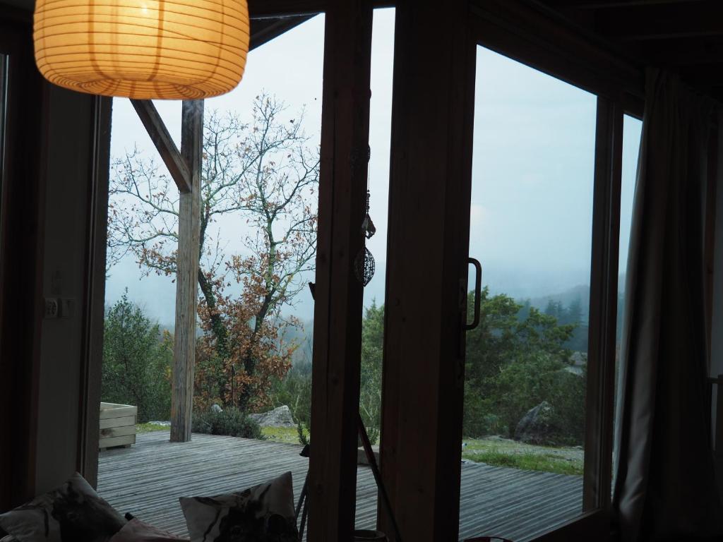 a room with a glass door looking out onto a deck at Les Faveyrolles à Labeaume in Labeaume