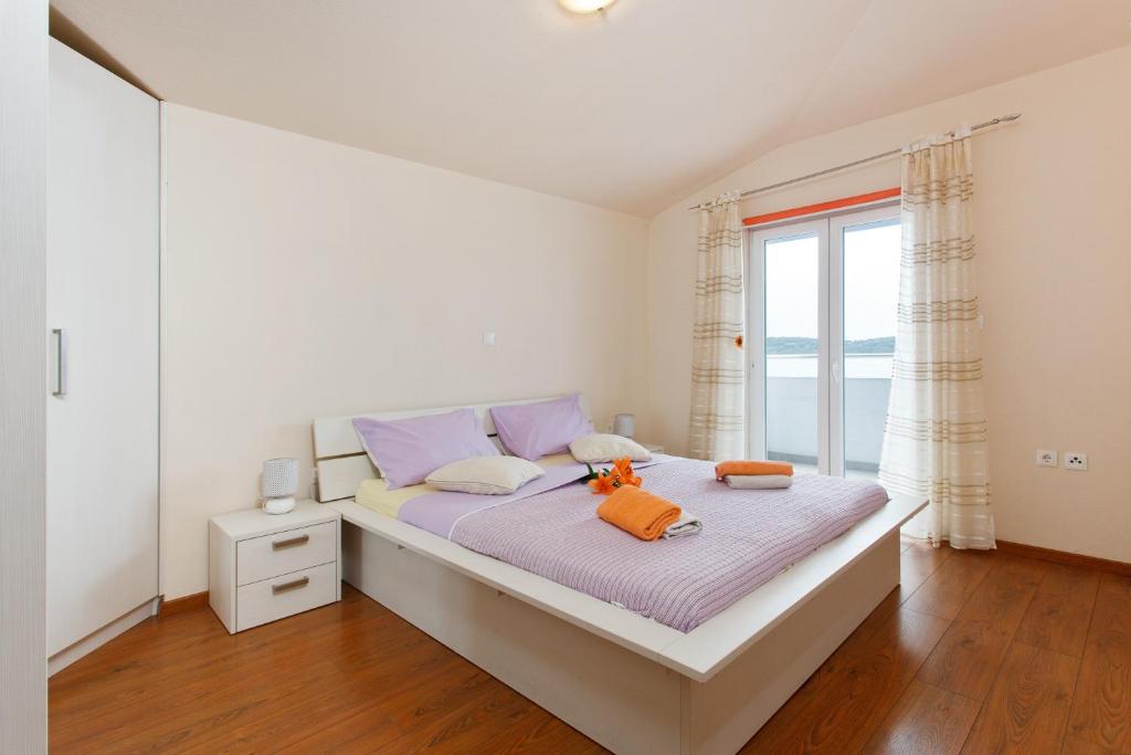 sypialnia z dużym łóżkiem i oknem w obiekcie Apartment Gold w Trogirze