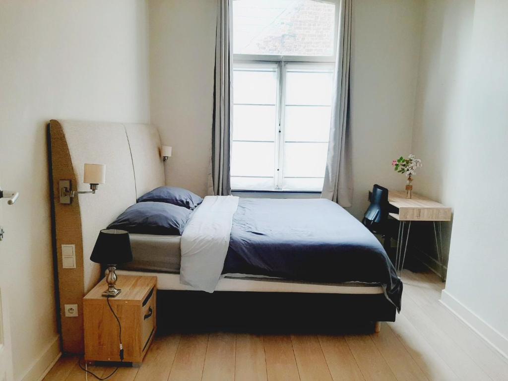 a bedroom with a large bed and a window at Superbe appartement au coeur du quartier européen in Brussels