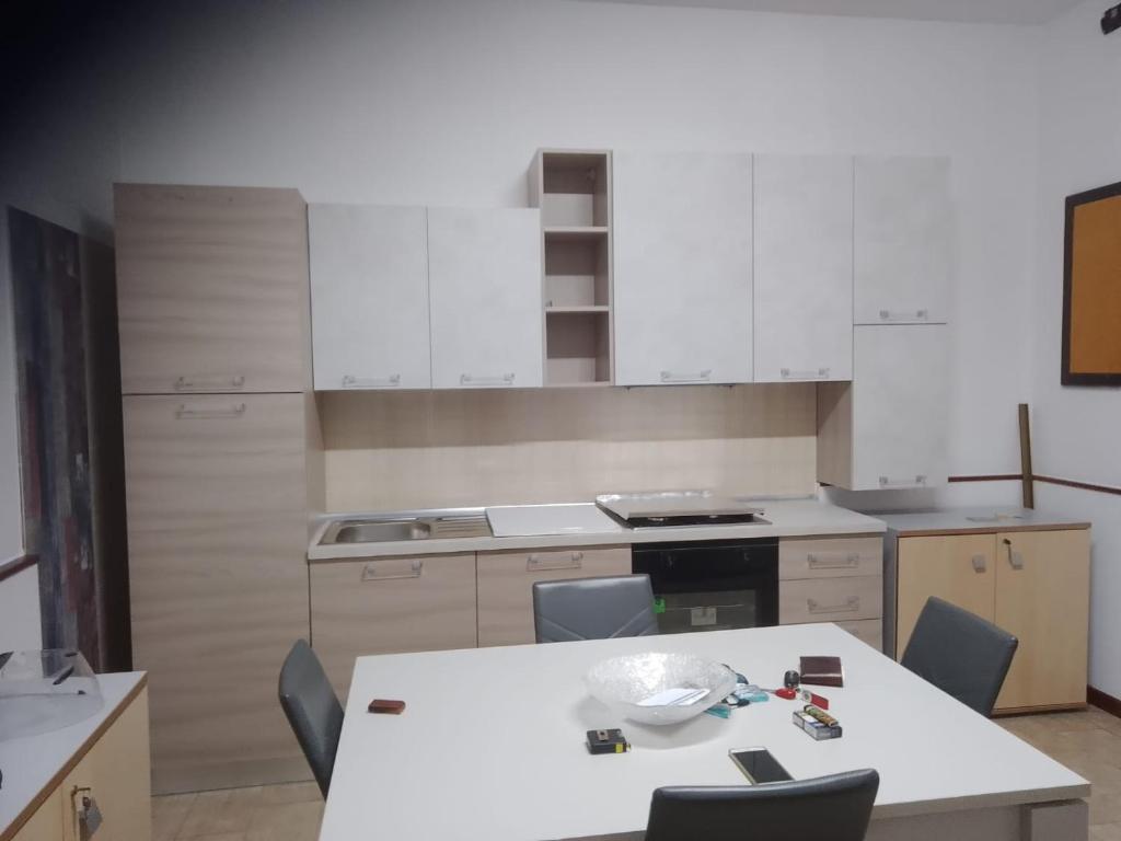 a kitchen with white cabinets and a table and chairs at casa vacanze Policoro in Policoro