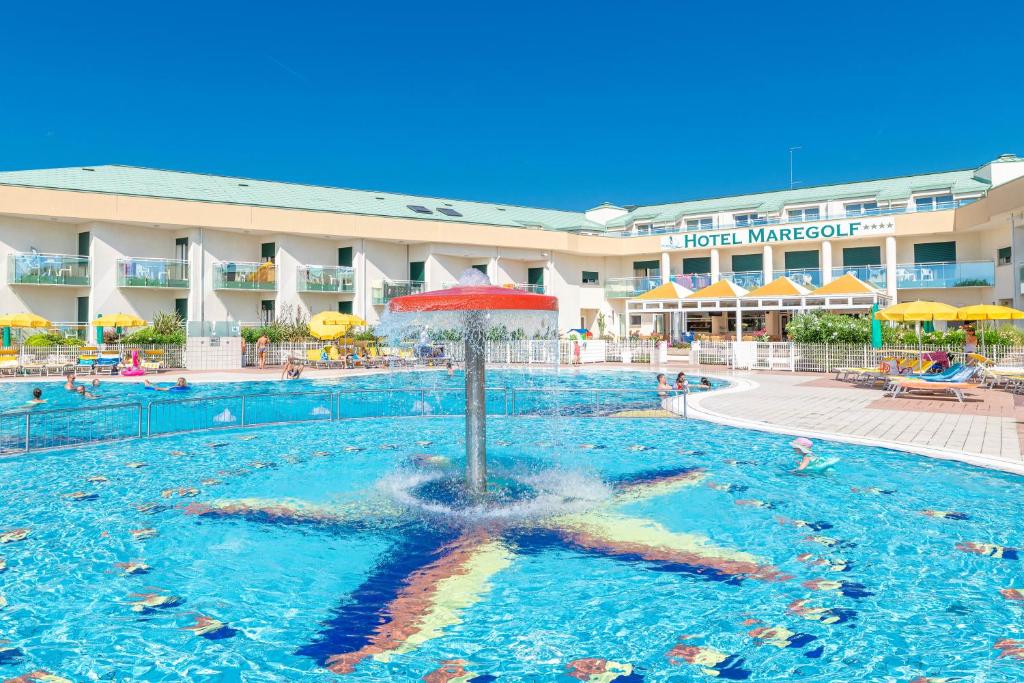 a pool at a hotel with a fountain in the water at Hotel Maregolf in Caorle