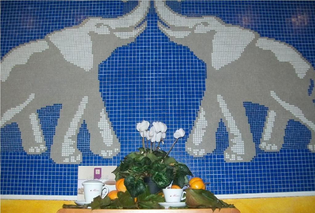 einen Tisch mit einer Pflanze und einer blauen Kachelwand in der Unterkunft B&B da Guerrino in Farra dʼAlpago