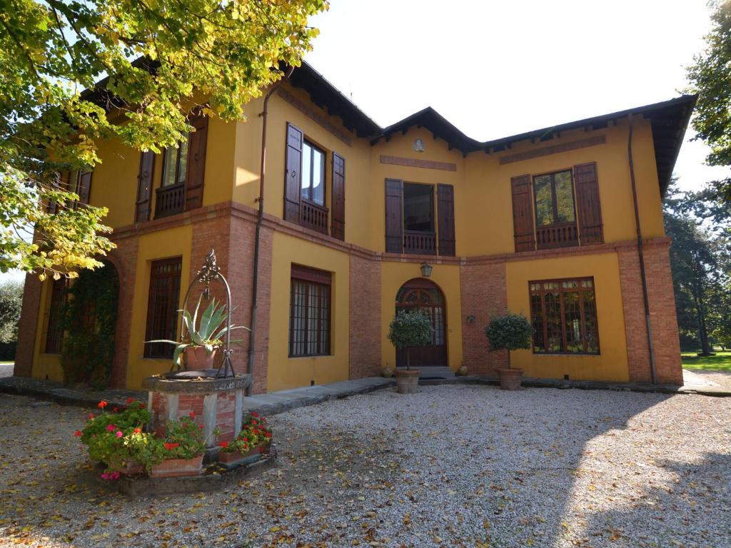 una grande casa gialla con dei fiori davanti di Elegant Holiday Home in Faenza with Garden and Pool a Faenza