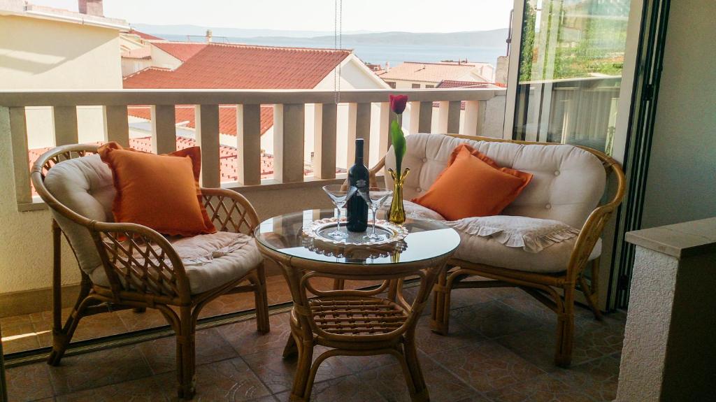 a balcony with two chairs and a table with candles on it at Holiday Home Granić in Baška Voda