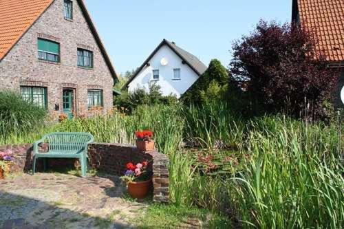 a garden with a bench and flowers and a house at Urlaubslust Ferienhaus 16 in Trassenheide