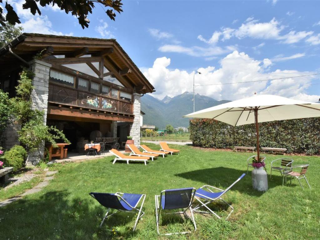 a group of chairs and an umbrella in the grass at Agriturismo La Ca' Vegia in San Cassiano