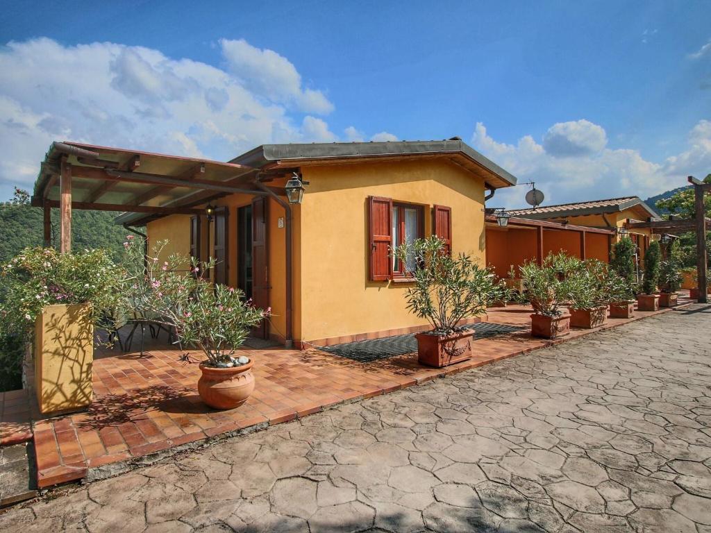 a house with potted plants in front of it at Country House with swimming pool and garden with Mediterranean plants in Bettona