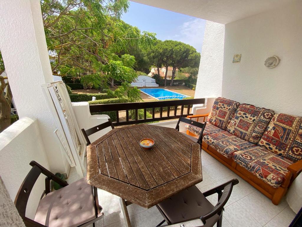 d'un balcon avec une table, des chaises et un canapé. dans l'établissement Apartament a Pals, amb piscina, platja a 1 minut, à Pals