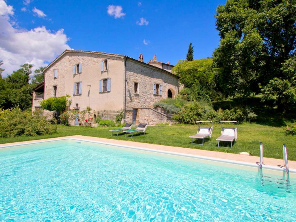 a house with a swimming pool in front of a building at Pretty Holiday Home in Acqualagna with Swimming Pool in Acqualagna