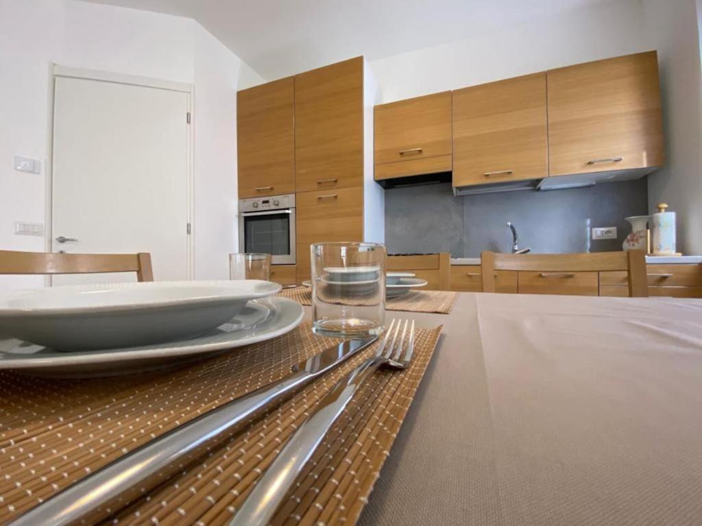 una mesa con platos y cubiertos. en appartamento Alpi Orobie, en Morbegno