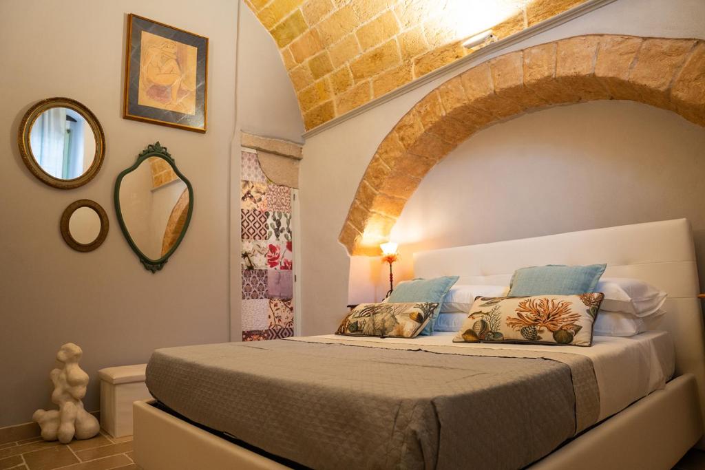 a bedroom with a large bed with an archway at LITHOS guest room in Barletta