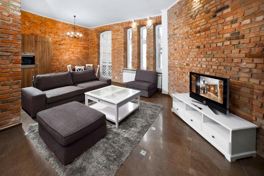 Televízia a/alebo spoločenská miestnosť v ubytovaní Apartamenty Pomarańczarnia