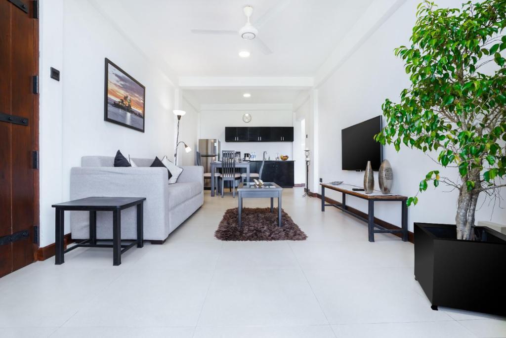 uma sala de estar branca com um sofá branco e mesas em Regent Heights em Kandy