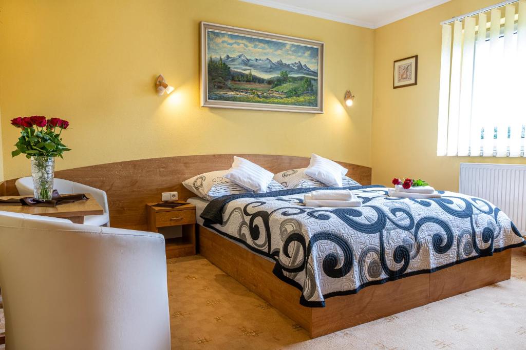 a bedroom with a bed and a vase of flowers at Apartmán u Vierky in Veľká Lomnica