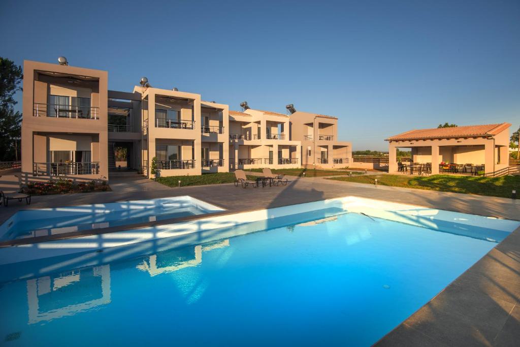 einem großen Pool vor einem Gebäude in der Unterkunft Apanemo Kourouta Luxury Villas in Kourouta