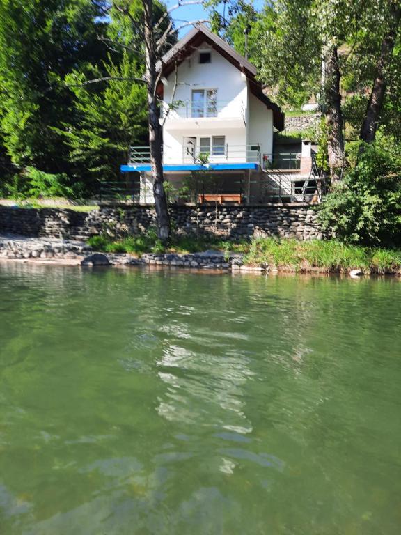 una casa sentada a orillas de un río en Vikendica krivaja Ribnica-Odmor na Krivaji, en Zavidovići