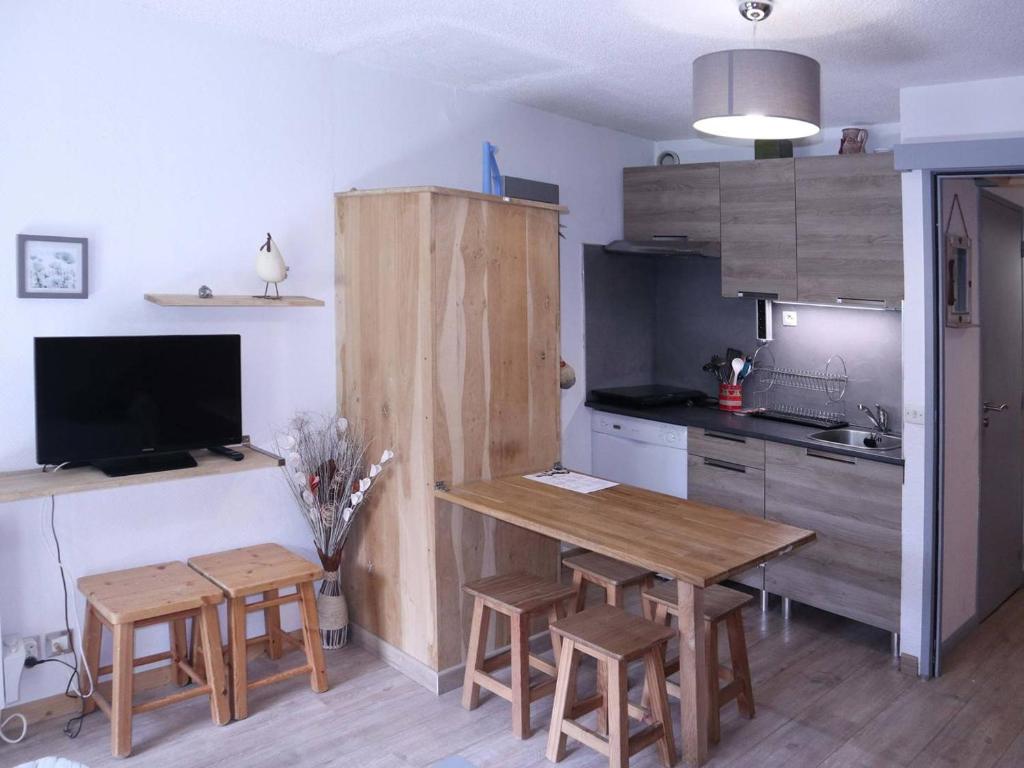 a kitchen with a wooden table and chairs and a kitchen with a counter at Studio Les Orres, 1 pièce, 4 personnes - FR-1-322-339 in Les Orres