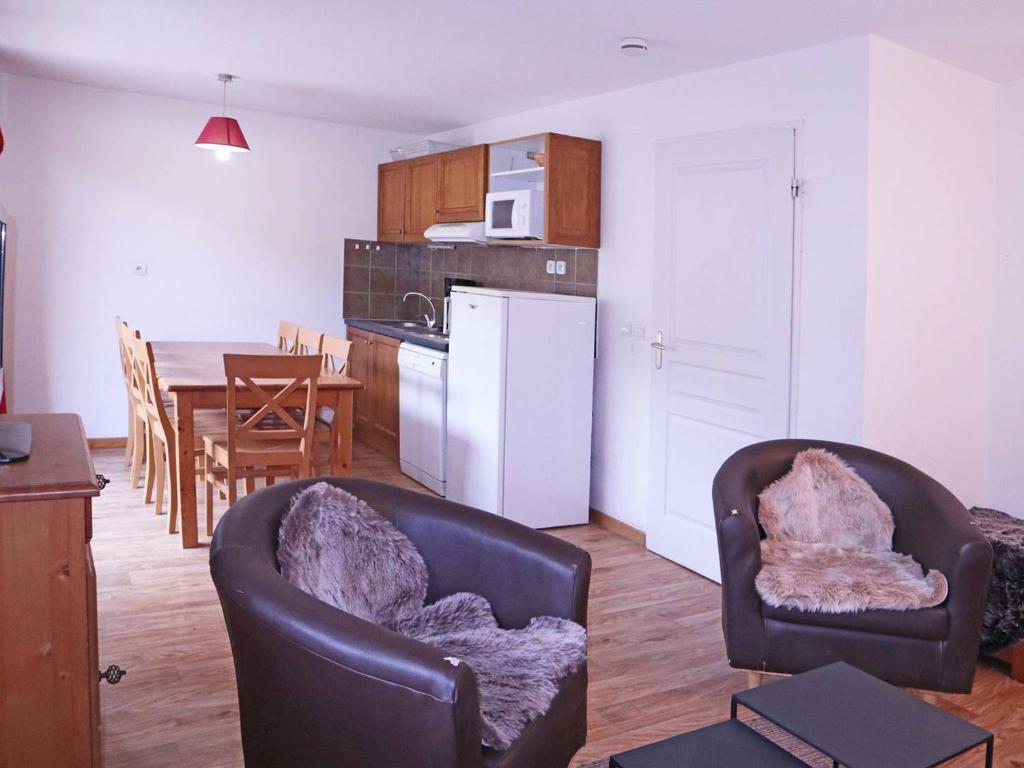 Il comprend une cuisine et une salle à manger avec des chaises et une table. dans l'établissement Superbe duplex 10 pers avec piscine et jacuzzi aux Orres 1800 - FR-1-322-206, aux Orres