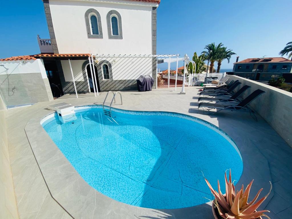 una piscina azul en un patio con un edificio en Villa Ivanlore, en Las Palmas de Gran Canaria