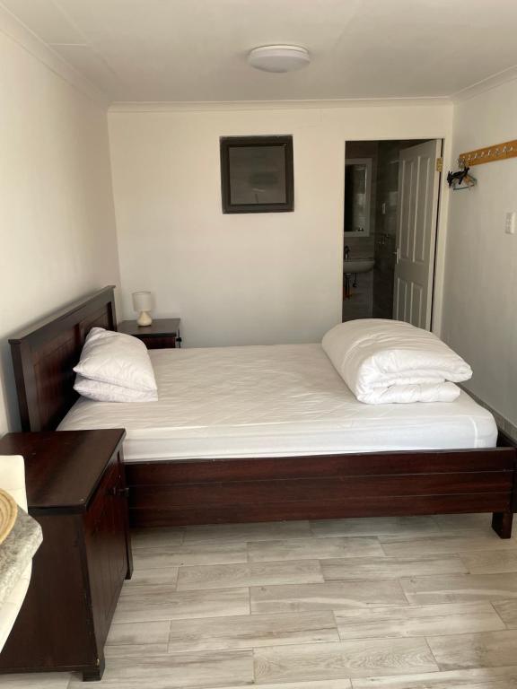 a bedroom with two beds with white sheets at The Oasis Accommodation in Lüderitz
