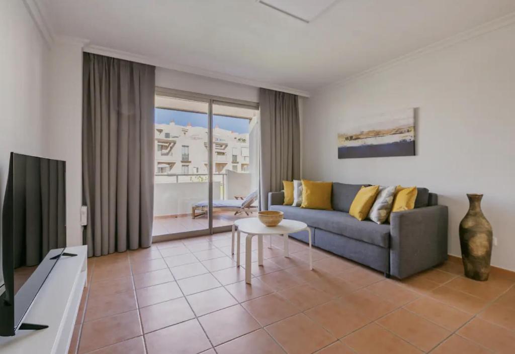 uma sala de estar com um sofá e uma mesa em Sunny Maria Apartment Tejita em Granadilla de Abona