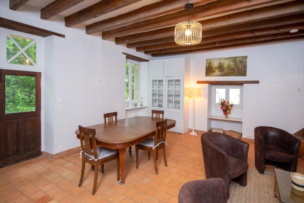 a dining room with a wooden table and chairs at La croix des vignes in Brossay