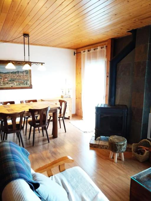 sala de estar con mesa y chimenea en Precioso apartamento en la Cerdanya (6 personas)., en La Molina