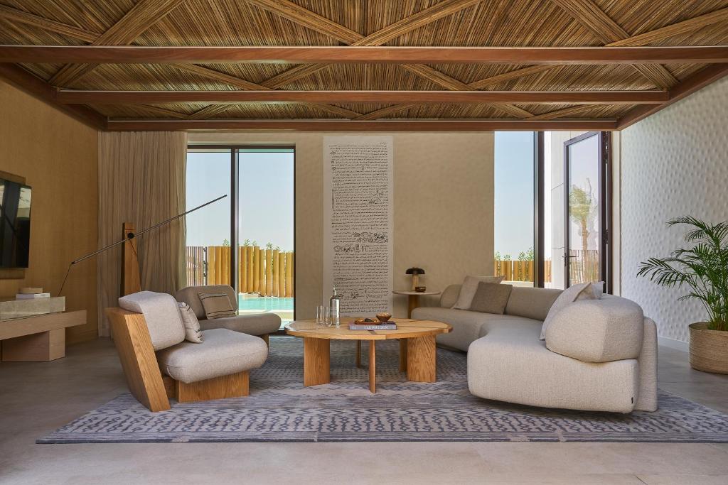a living room with a couch and two chairs and a table at ERTH Abu Dhabi Hotel in Abu Dhabi