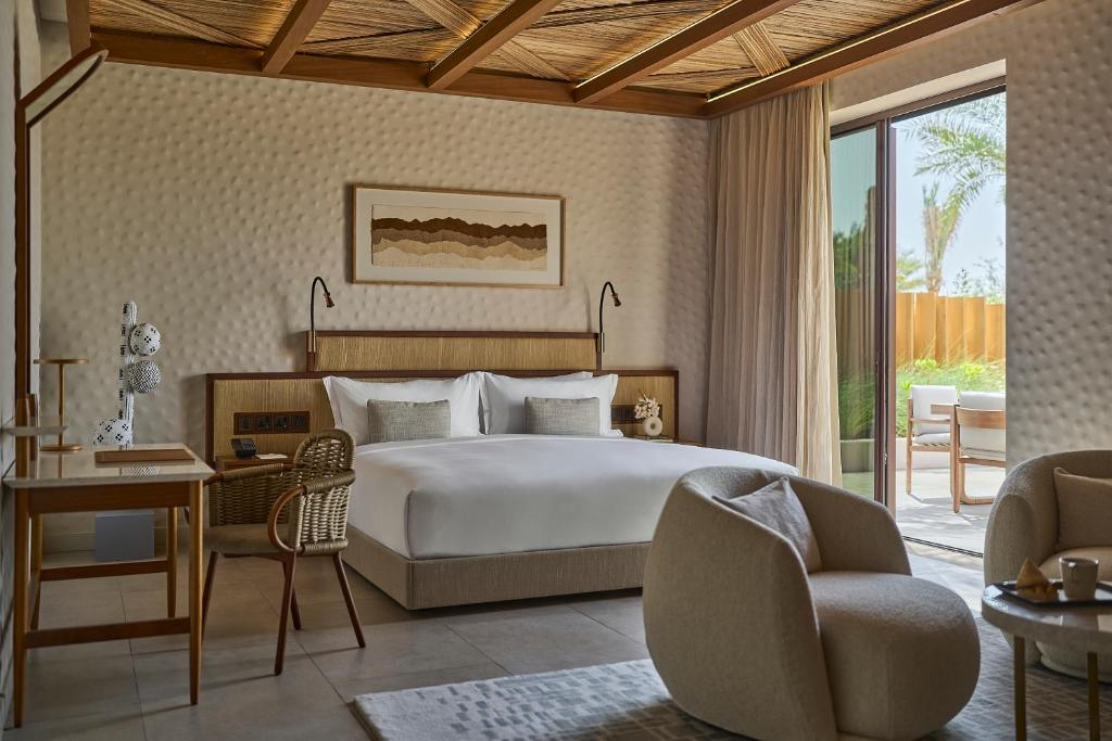 a bedroom with a bed and a desk and a chair at ERTH Abu Dhabi Hotel in Abu Dhabi