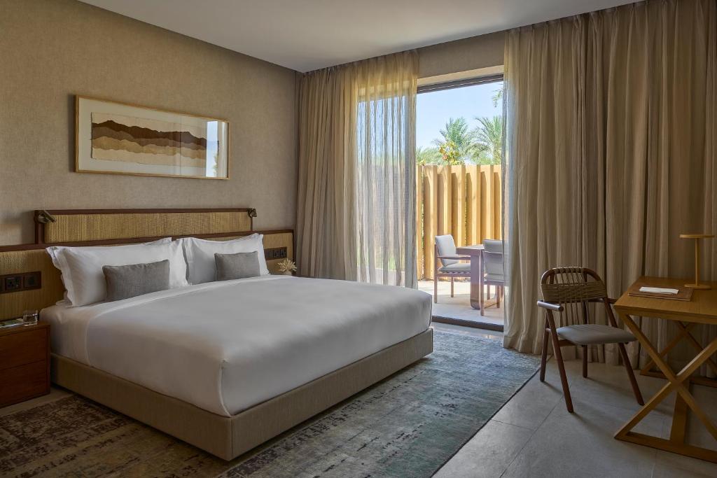 a hotel room with a bed and a sliding glass door at ERTH Abu Dhabi Hotel in Abu Dhabi