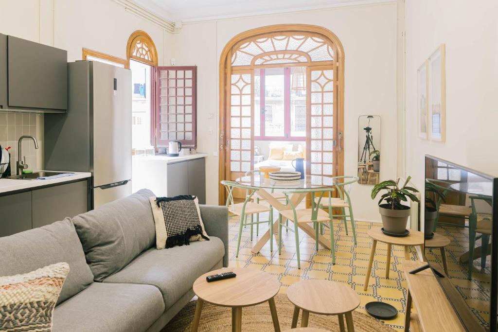 Aticco Living Gràcia - Apartments Rooftop في برشلونة: غرفة معيشة مع أريكة وطاولة