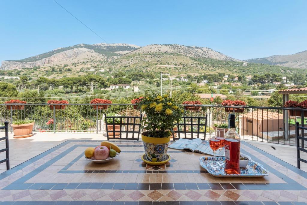 una mesa con un jarrón de flores en el balcón en Villa Salvatore en Torretta
