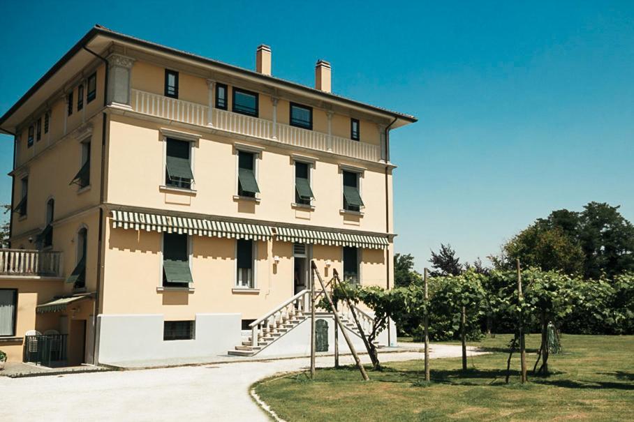 a large building with a staircase in front of it at Hotel Liberty in Spresiano