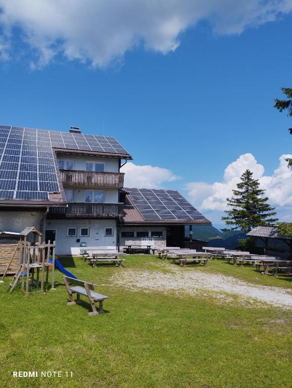 a building with solar panels on the side of it at Planinski dom Vrhe in Trbovlje