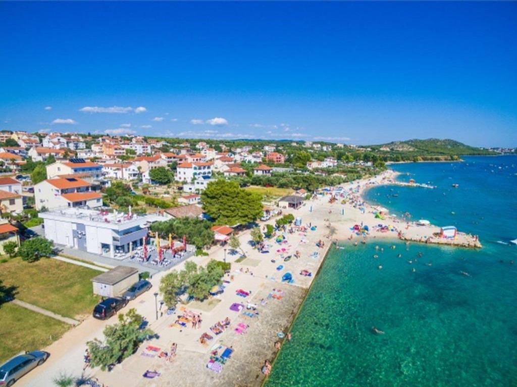 an aerial view of a beach with people and the water at Modern apartment right on the Janice beach in Pakostane centre 50 m away in Pakoštane