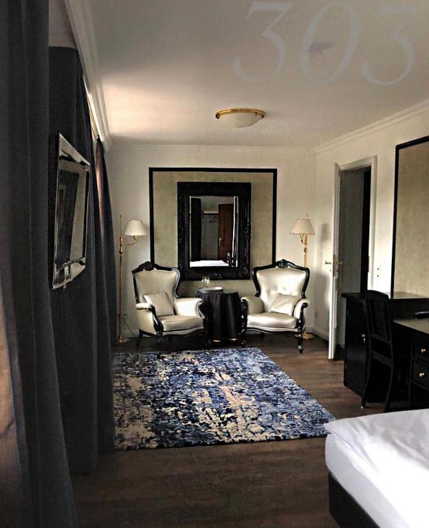 a living room with two chairs and a rug at Rein Klassik Hotel in Bad Pyrmont