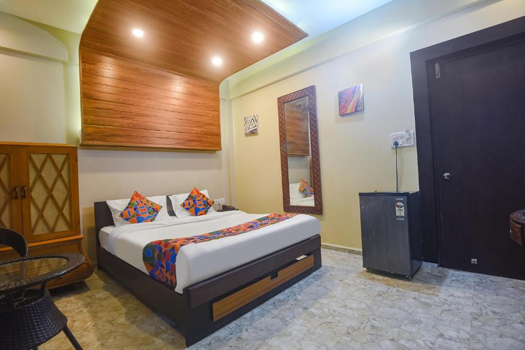 een slaapkamer met een bed, een tafel en een deur bij FabExpress Corinthia Boutique Rooms, Candolim Beach in Candolim