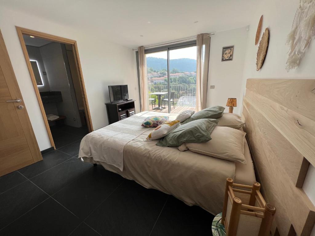 una camera da letto con un grande letto con una grande finestra di Villa l’écrin du Rayol a Le Rayol-Canadel-sur-Mer