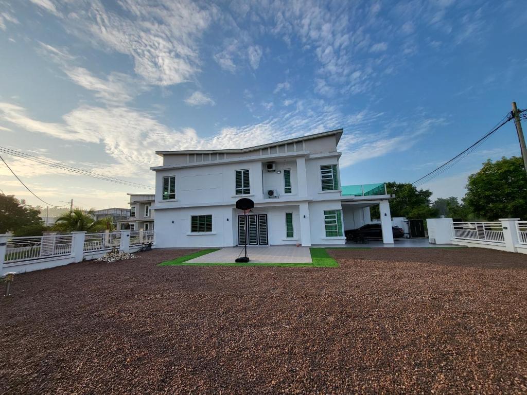 una casa blanca con una valla delante en Impiana Lakeview Villa - Contactless Check In en Kluang