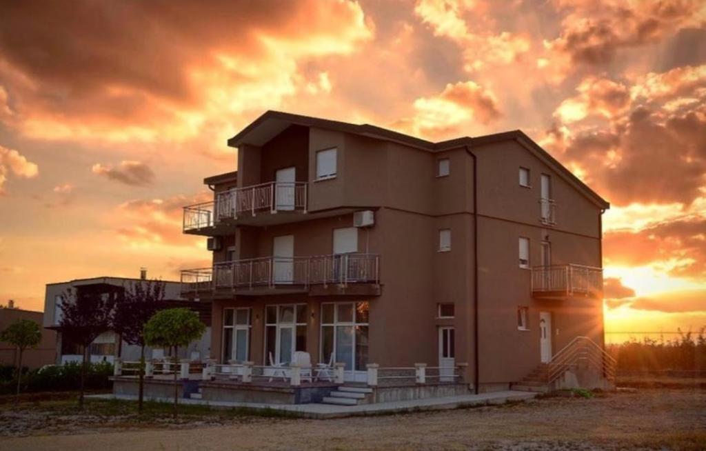 a large building with a sunset in the background at Villa Aurora in Međugorje