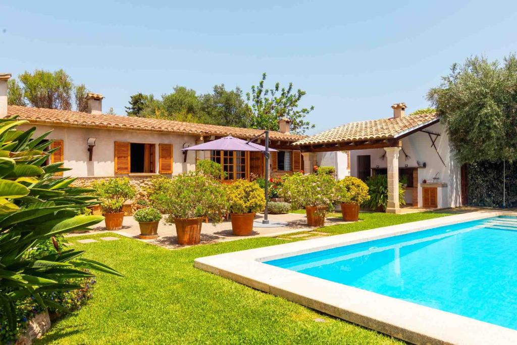 une villa avec une piscine en face d'une maison dans l'établissement Can Vadell, à Pollença