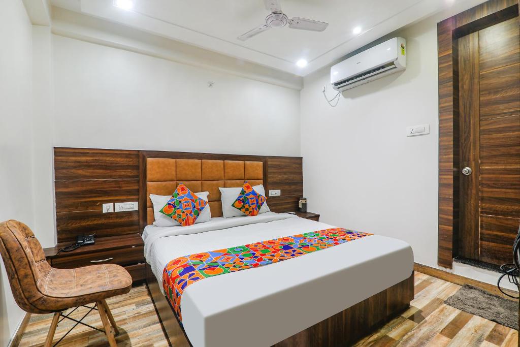 a bedroom with a bed and a desk and a chair at FabHotel Bless Inn in Allahābād