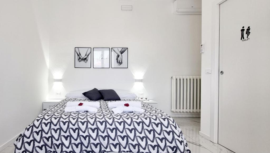 um quarto branco com uma cama em preto e branco em Guest Holiday Piave 4 em Reggio Emilia