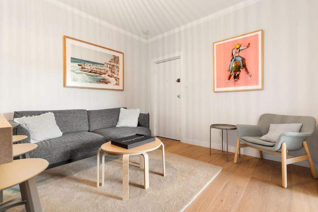 sala de estar con sofá y 2 sillas en Sunlit 2BR Coastal Charm Bondi Beach Beach View, en Sídney
