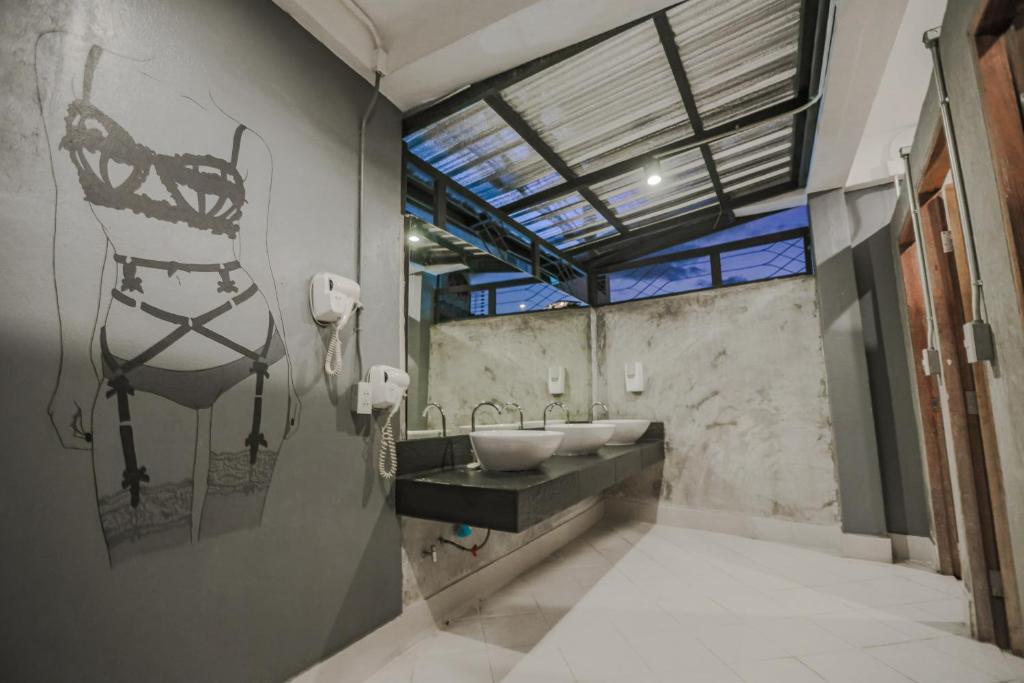 ein Badezimmer mit zwei Waschbecken und einer Glasdecke in der Unterkunft JAI bed and cafe in Chiang Mai