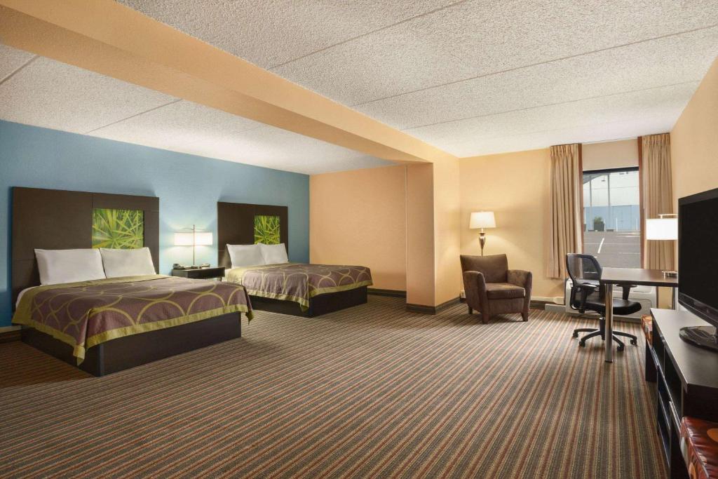 a hotel room with two beds and a desk at Super 8 by Wyndham Mount Laurel in Mount Laurel