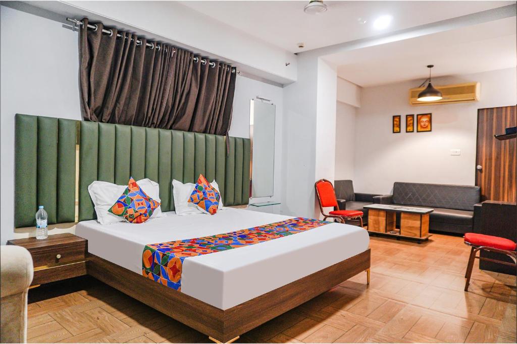 a bedroom with a bed and a living room at FabHotel Royale Celebrations in Surat