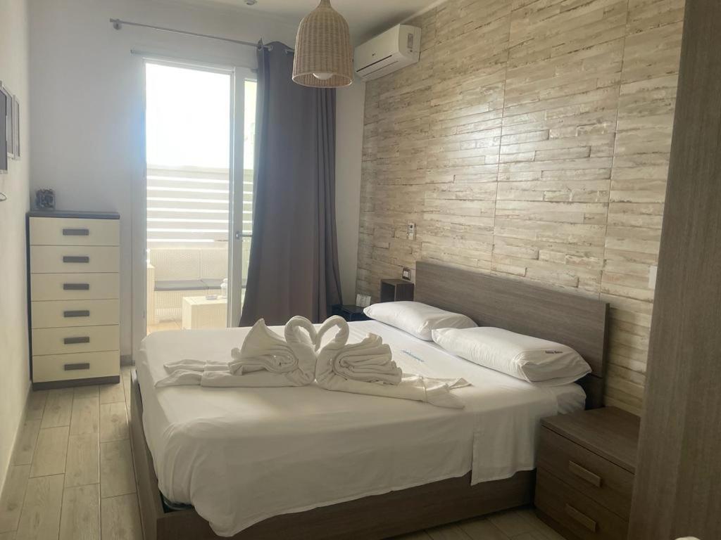 トッレ・ラピッロにあるSabbia Bianca Affittacamereのベッドルーム1室(弓の付いたベッド1台付)